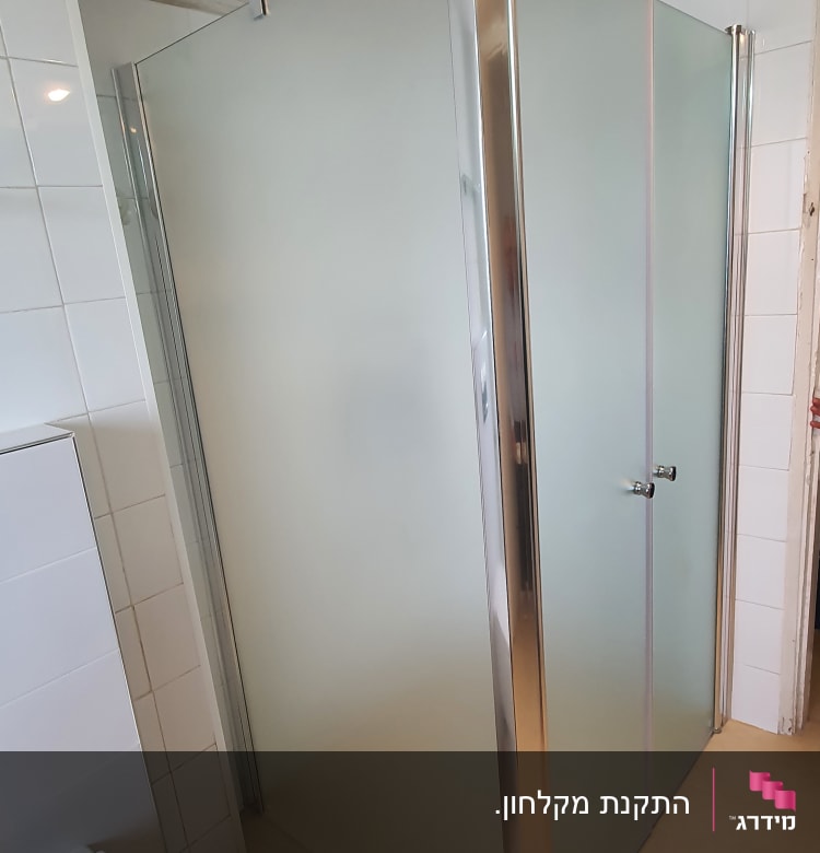 מקלחון זכוכית עם דלתות מתכת בחדר אמבטיה